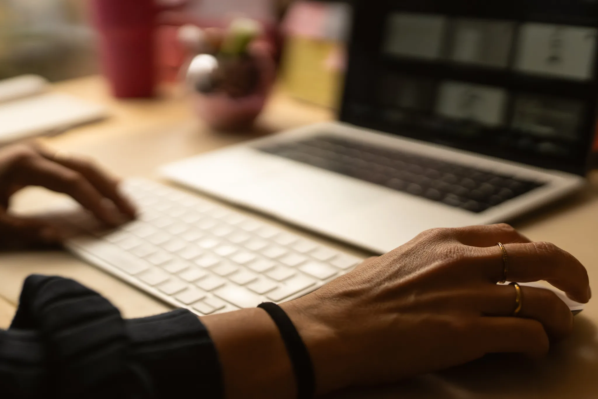 Person tippt auf einer Laptop-Tastatur, während der Fokus auf den Händen und der Tastatur liegt