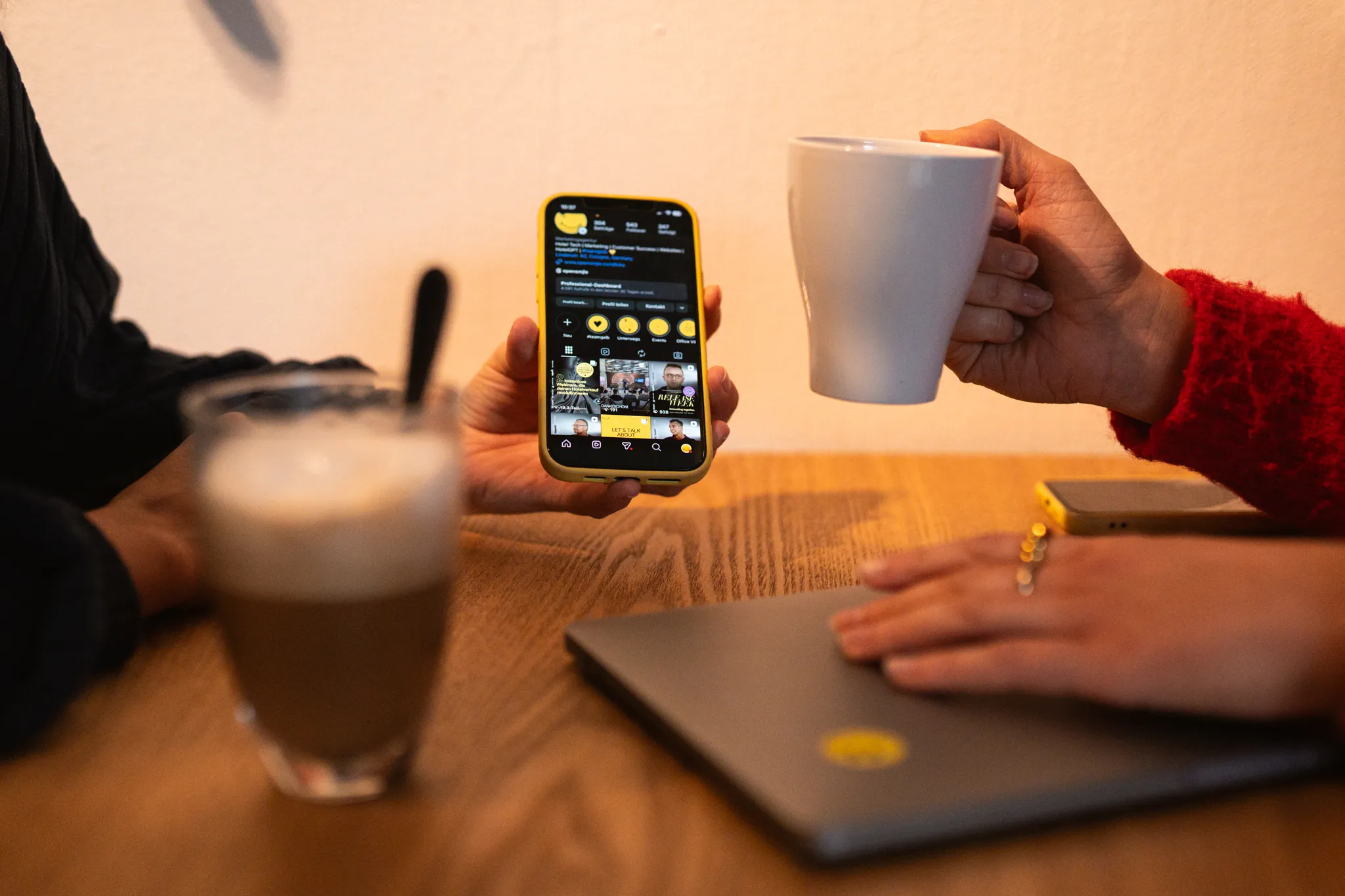 Two people holding smartphone and cup