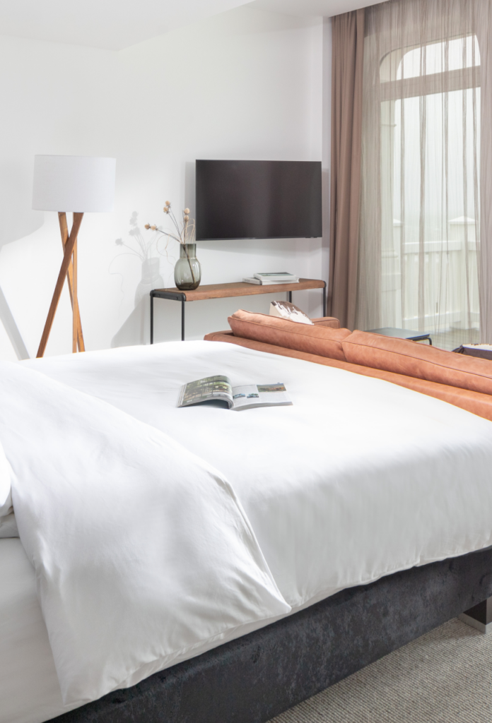 1884 Norderney: Modern eingerichtetes Hotelzimmer mit Doppelbett, Schreibtisch und bodentiefen Fenstern